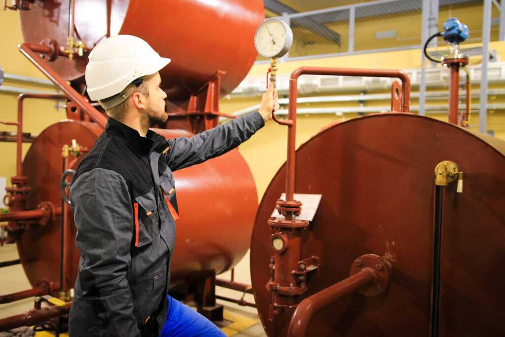 Technician Checking Gauge Of Pressure On Oil Tanks. Worker On Pl - RE:Group